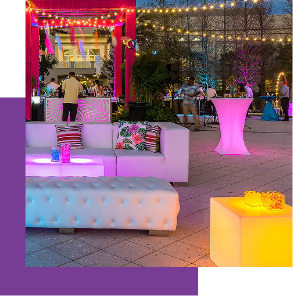 Beach lounge with colorfully lit tables and chic furniture. 